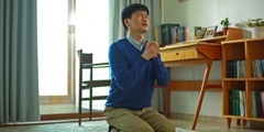 Mladý muž sa na kolenách úpenlivo modlí