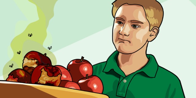 Um jovem olha para uma bandeja com maçãs podres