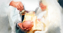 Ksiądz polewa wodą głowę niemowlęcia podczas chrzcin.