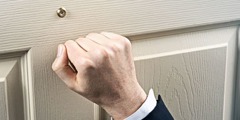 Een Getuige van Jehovah die op een deur klopt