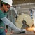 A metalworker uses a chop saw to cut studs for the office walls
