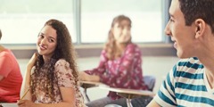 En teenagepige flirter med en dreng i klassen