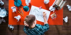 Teini-ikäinen poika yrittää piirtää hevosta; hän on heittänyt pois jo monta luonnosta