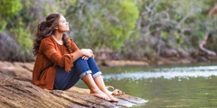 Uma adolescente sentada perto de um lago