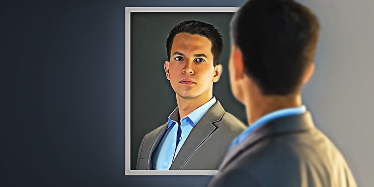 A young man looks at himself in a mirror
