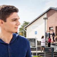 A young man observes people walking into a Kingdom Hall