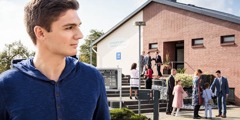 A young man observes people walking into a Kingdom Hall