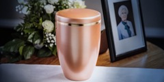 Cremation urn next to a picture of the deceased