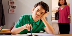 Egy fiú küszködik a házi feladatával