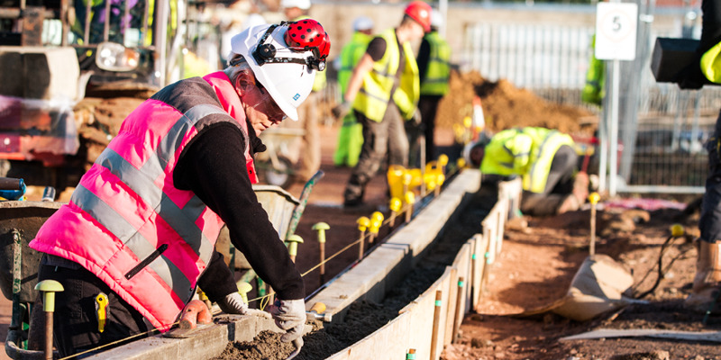 Une femme travaille avec des hommes sur le chantier de construction de la filiale à Chelmsford