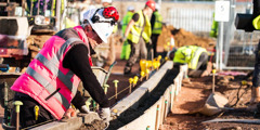 Një grua duke punuar përkrah burrave në ndërtimin e degës në Çelmsford