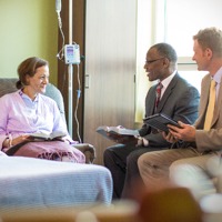 Two elders who serve on a Patient Visitation Group visit one of Jehovah’s Witnesses in a hospital