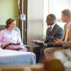 Dy pleq që shërbejnë te një Grup i Vizitave te Pacientët vizitojnë një Dëshmitare të Jehovait në spital