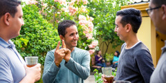 Mario Antúnez using Honduras Sign Language (LESHO) to communicate with three brothers at a social gathering.
