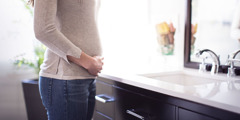 A pregnant woman stands in front of a mirror