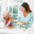 Egy nő kedvesen ennivalót ad az idős édesanyjának