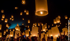 Persone guardano le lanterne che salgono verso l’alto durante la celebrazione di Vesak