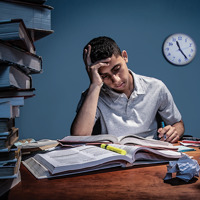 A teenage boy doing his homework late at night.