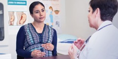 En gravid kvinne snakker med en helsearbeider