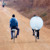 Broeders die met de fiets via een zandweg satellietapparatuur naar hun gemeente vervoeren.
