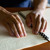 Nevidomá žena čte pomocí prstů publikaci v Braillově písmu