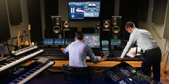 Braća u studiju obrađuju snimak pesme koristeći kompjutere i drugu opremu.