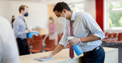 Two brothers wearing masks, disinfecting touch points at a Kingdom Hall.