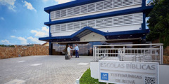 En bror byder et par varmt velkommen ved en skolebygning i Brasilien.