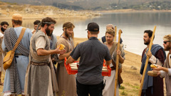 A brother bringing a tray of sandwiches to cast members at an outdoor filming location.