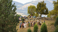 A scene being filmed in a remote area with many hills and trees.