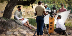 A film crew preparing to shoot an outdoor scene for an episode of “The Good News According to Jesus.” The brother who portrays Jesus sits under a tree.