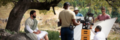 El equipo de rodaje se prepara para grabar en exteriores una escena de un episodio de “Las buenas noticias según Jesús”. El hermano que hace de Jesús está sentado bajo un árbol.